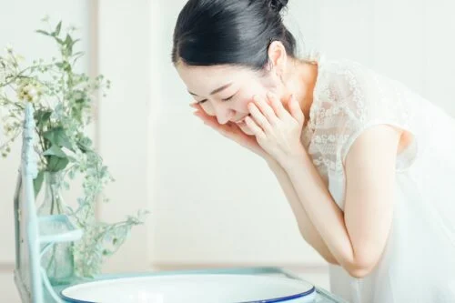 洗顔料で顔をやさしく洗う女性の横顔